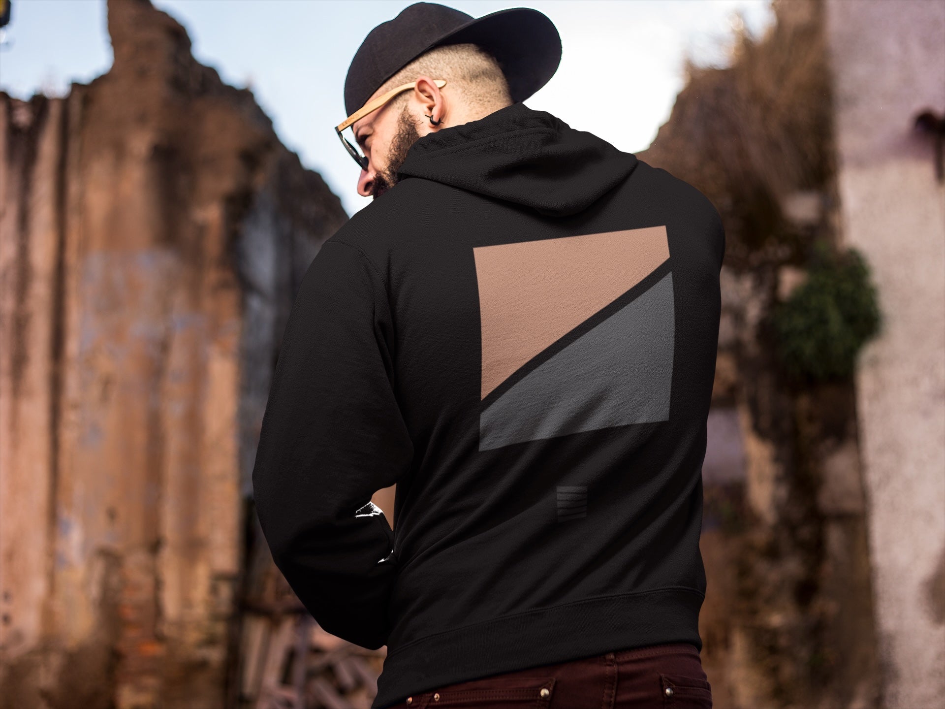 Schwarzer Hoodie mit geometrischem Road-Print in Kupfer und Anthrazit auf der Rückseite.