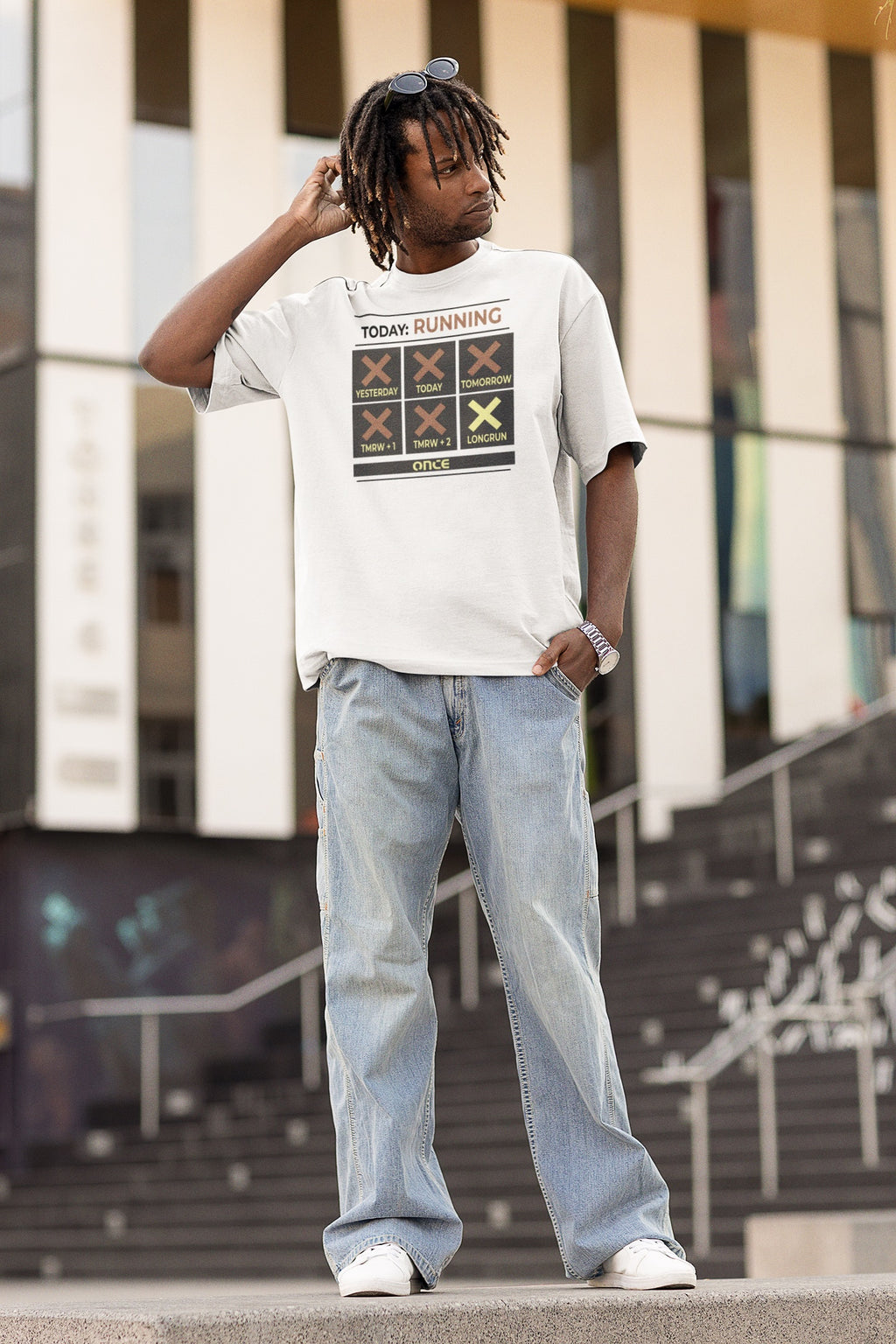 Model trägt weißes T-Shirt mit grafischem Running-Kalender und dem Schriftzug „TODAY: RUNNING“ auf der Vorderseite.